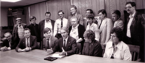 Wisconsin Governor Tony Earl signs legislation to provide for advance notice to workers 
in case of a plant closing. Darryl viewed on the left of the Governor and Future 
Milwaukee mayor, John Norquist, in second row.  Photo: Joanne Ricca.